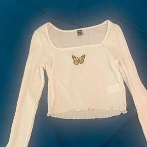 A long sleeve white shirt with butterfly